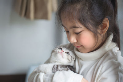 Close-up of girl holding kitten