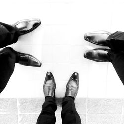 Low section of man standing on tiled floor