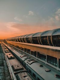 Train on railroad tracks against sky during sunset