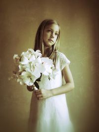 Close-up of woman holding white flowers