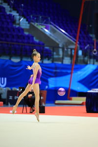 Girl gymnast performs an exercise with a ball