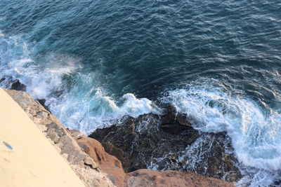 High angle view of waves splashing on rocks