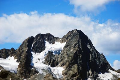 Low angle view of snow covered mountain against sky
