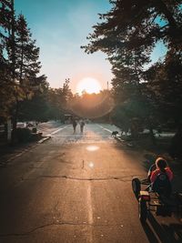 People on street against sky during sunset