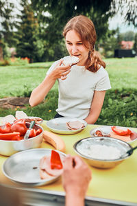 Family having breakfast outdoors on camping during summer vacation