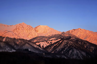 Scenic view of mountains against clear blue sky