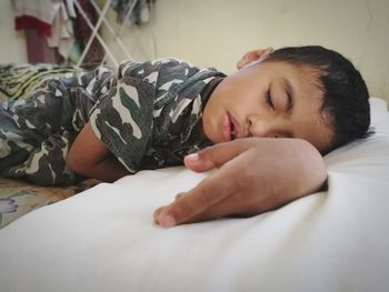 Close-up of baby sleeping on bed at home