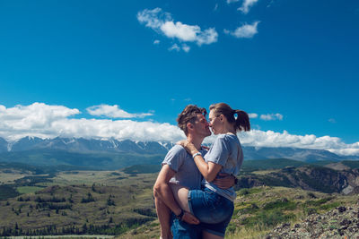 Rear view of couple on mountain against sky