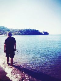 Rear view of woman standing on shore