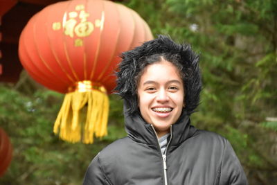 Portrait of smiling boy with balloons at park