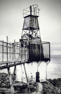 Built structure by sea against clear sky