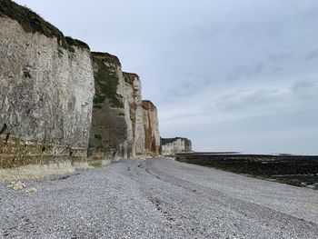 Road amidst rocks against sky