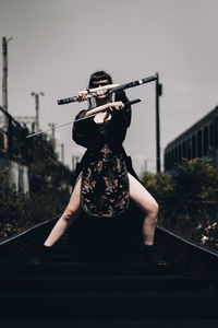 Woman standing on railroad track against sky