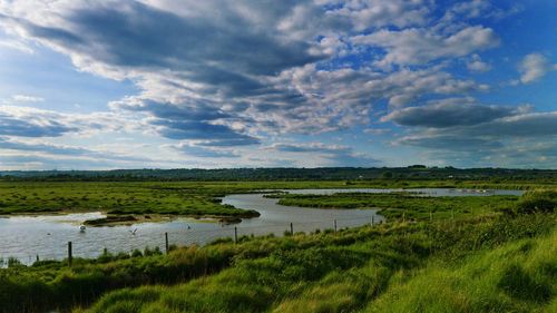 Photo of a winding river and the clouds in the sky. the clouds fill the sky drawing your attention. 