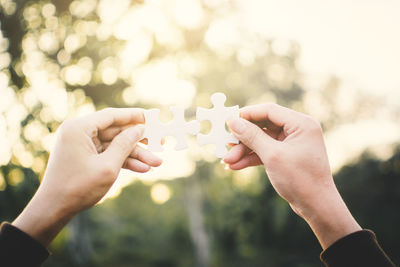 Midsection of couple holding heart shape with hands