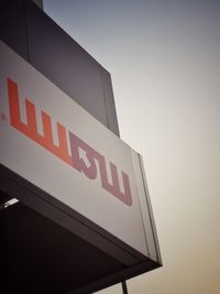 Low angle view of sign board against sky