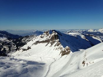 Scenic view of snowcapped mountains against clear blue sky