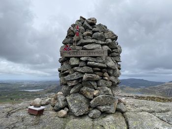 A cairn on mountain peak against sky