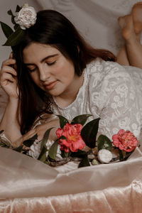 Portrait of woman with red roses in bed