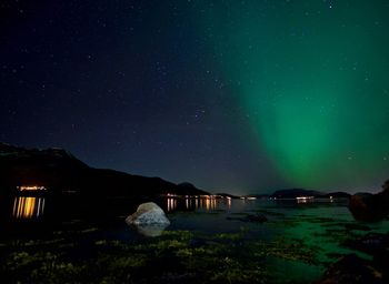 Scenic view of lake against sky at night