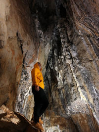 Low angle view of man standing on rock in cave