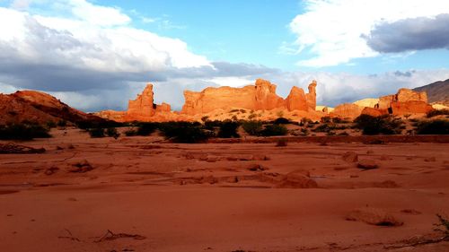 View of desert against cloudy sky