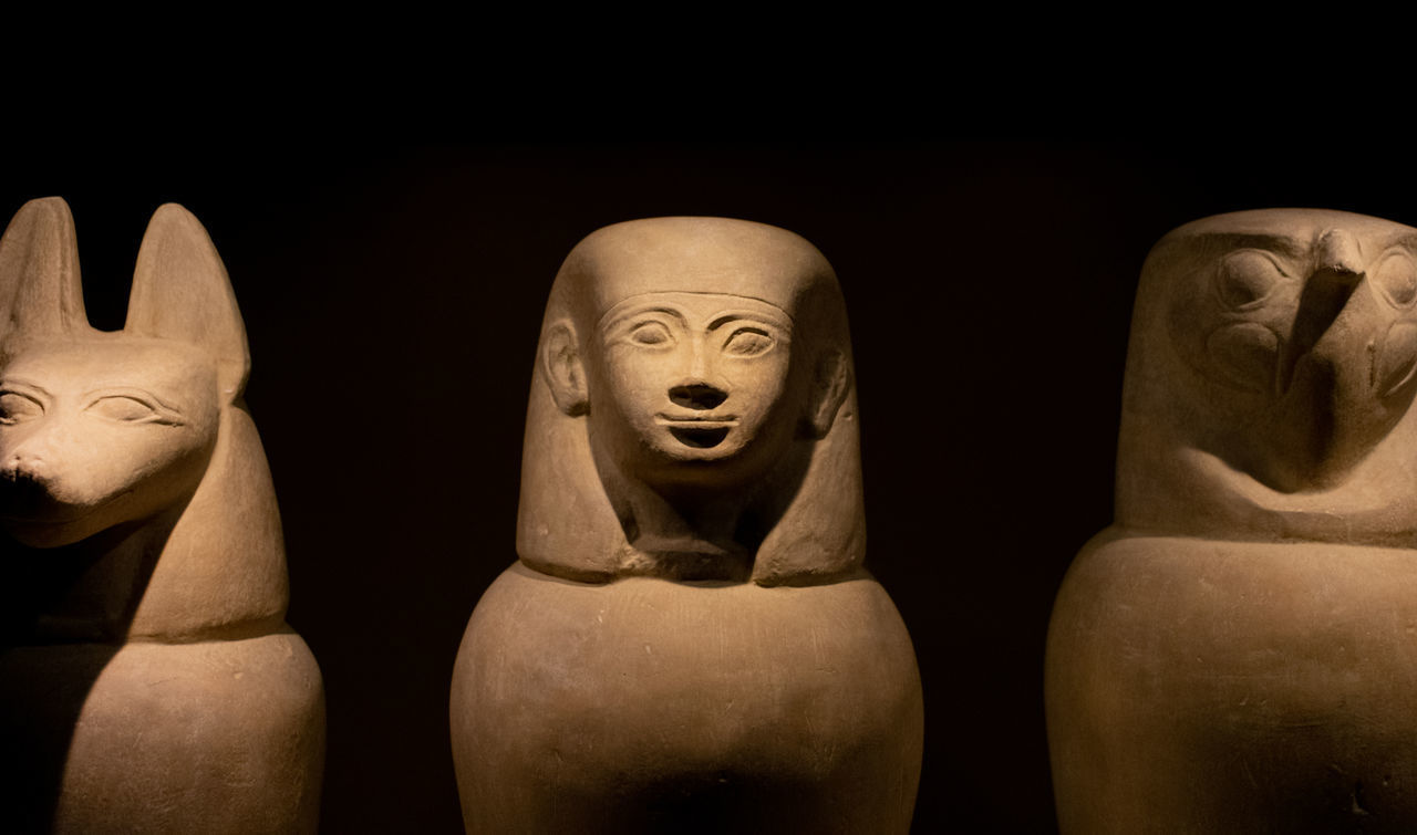CLOSE-UP OF STATUES AGAINST BLACK BACKGROUND