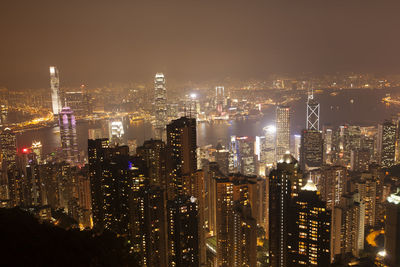 Illuminated cityscape against sky at night