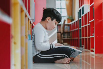 Asian little boy reading a book at school, close up