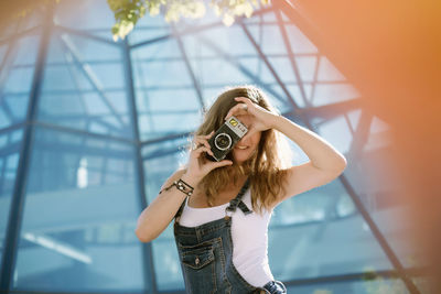 Full length portrait of woman standing against wall