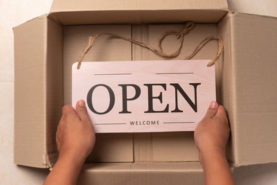 Low section of woman holding paper with text