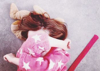 High angle view of girl hiding face while lying on couch