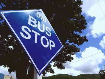 Low angle view of road sign against blue sky