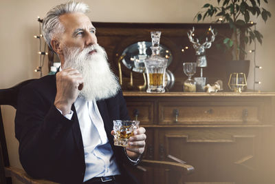 Thoughtful man drinking alcohol at home