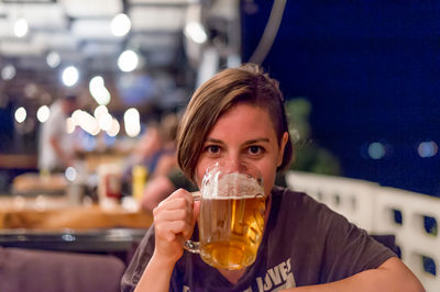 Close-up of young woman drinking beer