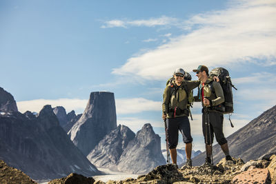 People standing on mountain against sky