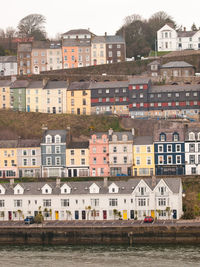 Houses by canal against buildings in city