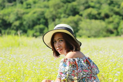 Portrait of smiling woman wearing hat on field