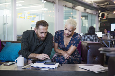 Business people using tablet computer while sitting in office