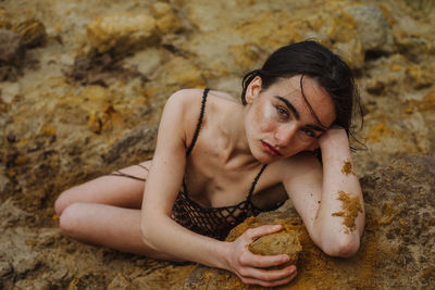 Portrait of young woman lying outdoors