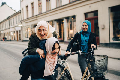 Portrait of smiling young woman on bicycle in city