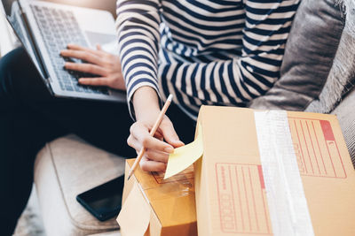 Midsection of woman using laptop at office