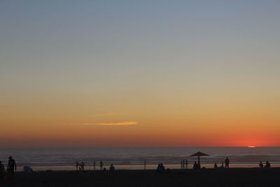 Scenic view of beach against clear sky during sunset