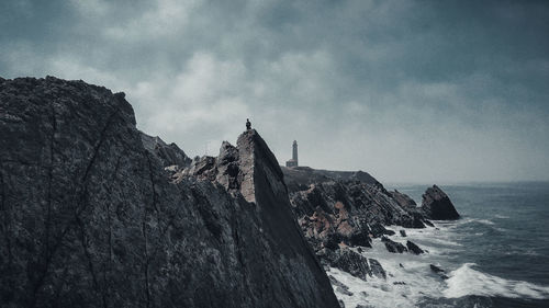 Rock formations on beach against sky