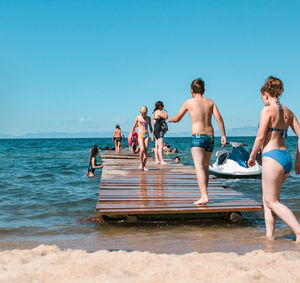 People on beach against clear sky