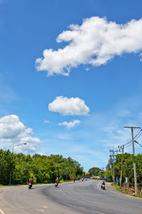 People on road against blue sky