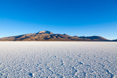 Scenic view of beach against clear blue sky