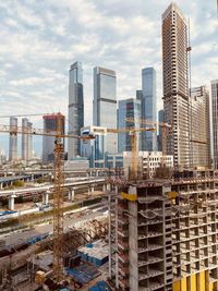 Construction works against the background of moscow skyscrapers and cloudy sky in summer.