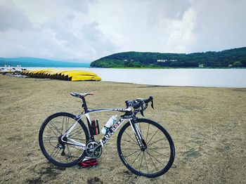 Bicycles on beach against sky