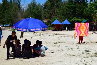 Rear view of men sitting on beach